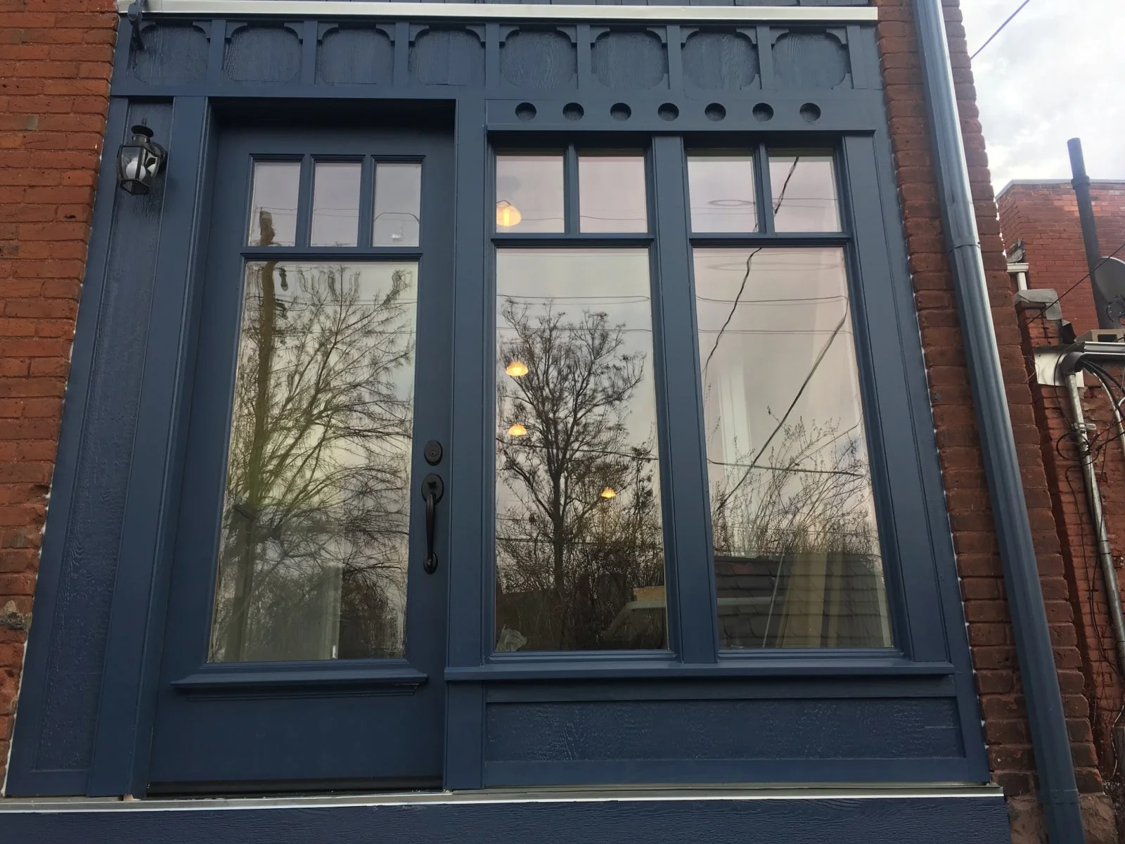 A custom period correct wood double-hung window installed in an Atlanta historic home, showing true divided lights and a painted wood exterior casing that matches the original millwork profile. The surrounding trim and sill depth reflect the architectural era of the facade.